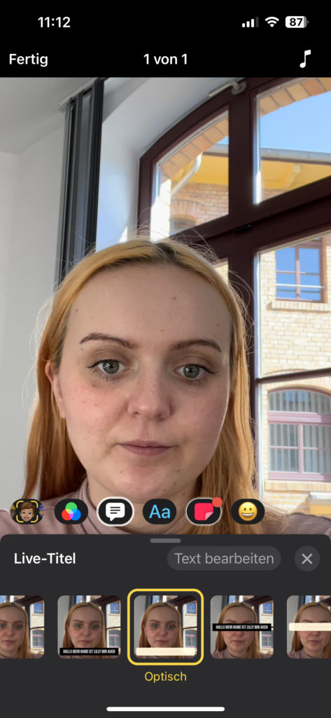 Screenshot 2: Benutzeroberfläche der App Clips: Im oberen Teil des Bildschirms ist das Bild der jungen Frau zu sehen, im unteren Teil das Menü der App. 5 Symbolen sind nebeneinander dargestellt: Hier ist die Sprechblase ausgewählt (weißer Rahmen). Darunter steht "Live-Titel", rechts daneben “Text bearbeiten”. Darunter sind 5 kleine Quadrate, in denen das Bild der Frau in Klein zu sehen ist, mit jeweils unterschiedlichen Varianten von Untertiteln; dies ist das Menü zum Auswählen des Untertitel-Stils. 