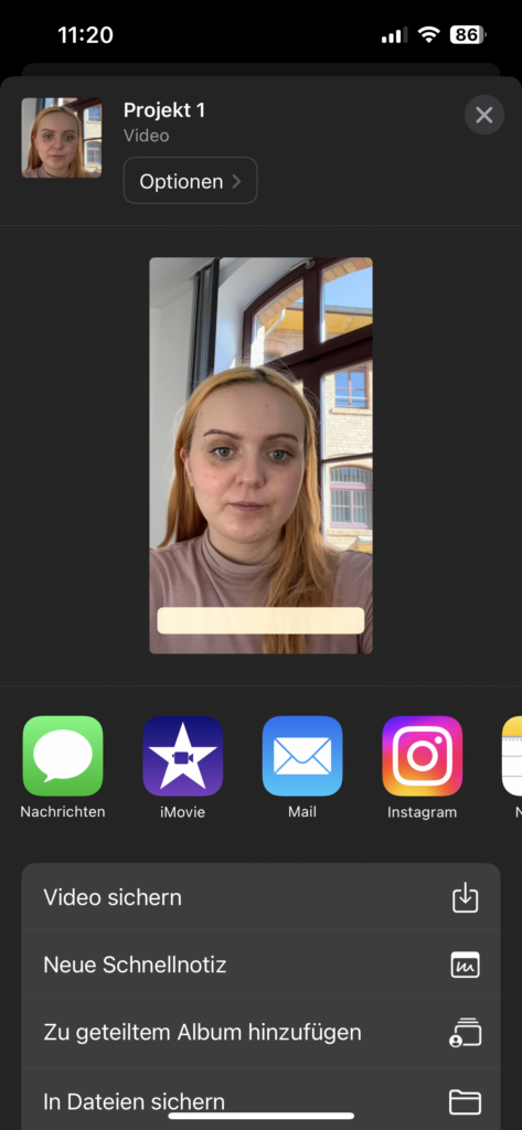 Screenshot 3 : In der oberen Hälfte der Benutzeroberfläche ist ein Standbild des Videos zu sehen: Die junge Frau und die Fläche für den Untertitel. Darunter befinden sich die Symbole der App, mit denen geteilt werden kann: per Nachricht, iMovie, per E-Mail und per Instagram. In einem grauen Kasten darunter stehen 4 Menüpunkt mit einem jeweiligen Symbol:  “Video sichern”, “Neue Schnellnotiz”, “zu geteilten Album hinzufügen”, “in Dateien sichern”.